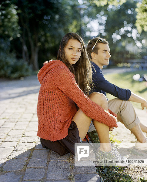 A couple sitting in a park.