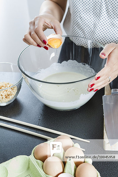Woman preparing dough for Okonomiyaki in a glassbowl