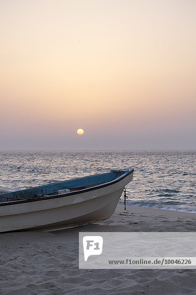 Oman  Ras al-Jinz  Sonnenaufgang und ein Fischerboot an der Küste