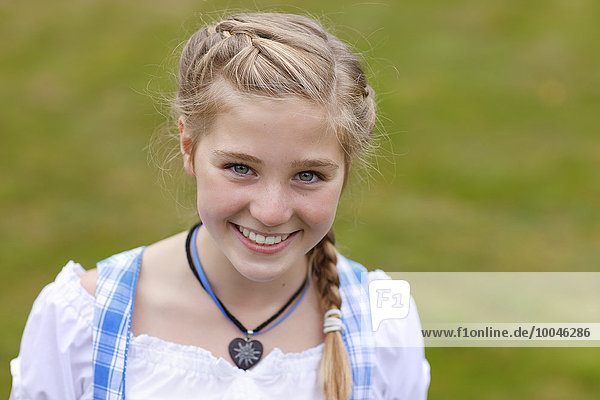 Deutschland  Lüneburger Heide  Porträt eines lächelnden blonden Mädchens im Dirndl