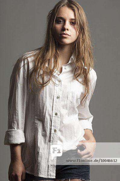 Porträt einer Teenagerin mit langen braunen Haaren in weißer Bluse