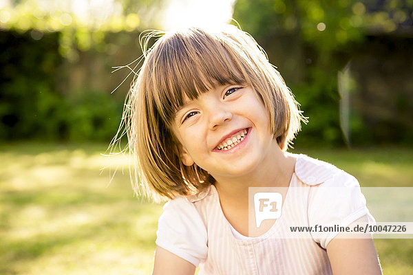 Portrait of smiling little girl in a garden