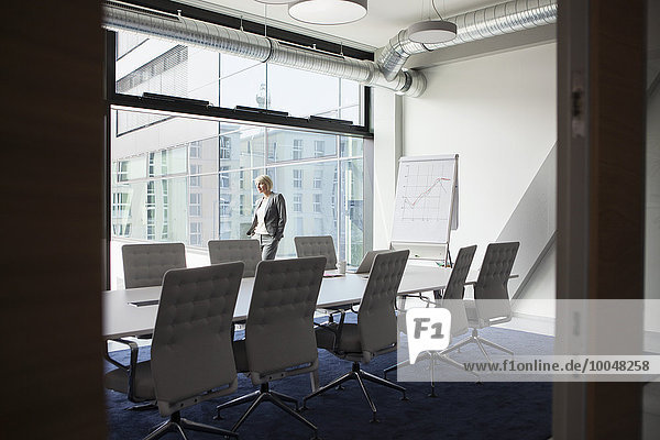 Female manager in conference room looking out of window