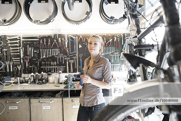 Young woman working in a bicycle repair shop