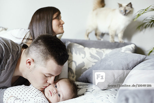 Junge Familie mit Katze im Wohnzimmer