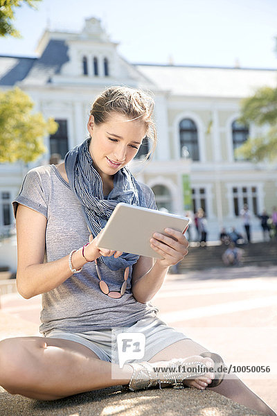 Junge Frau mit digitalem Tablett im Freien