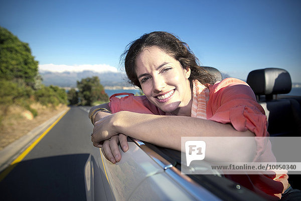 Südafrika  glückliche Frau im Cabrio auf der Küstenstraße