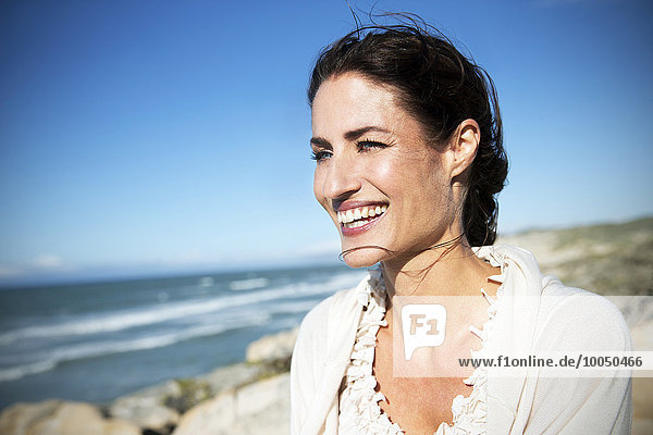 Südafrika  Porträt einer lächelnden Frau mit Blick aufs Meer