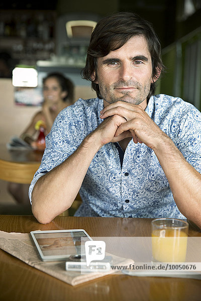 Porträt eines Mannes  der in einem Café wartet.