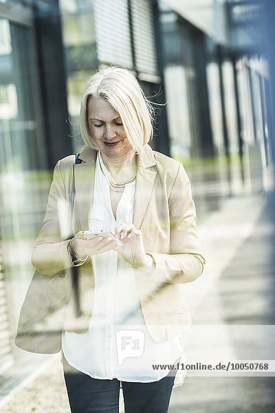 Reife Frau mit dem Handy