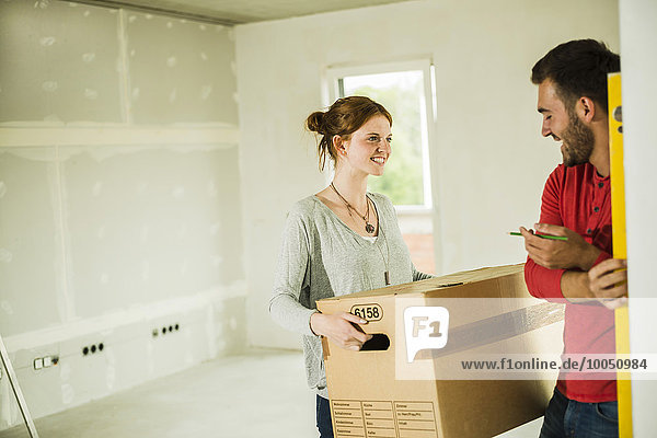 Smiling young couple moving house