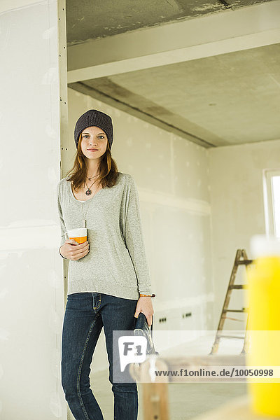 Young woman having a coffee break from renovating
