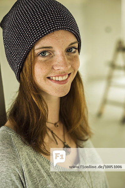 Portrait of smiling young woman wearing a cap