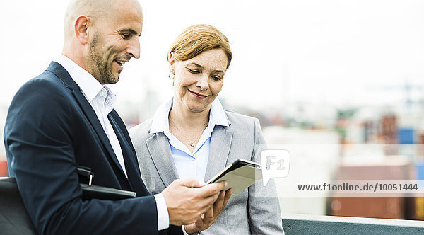 Geschäftsmann und Geschäftsfrau teilen sich digitales Tablett