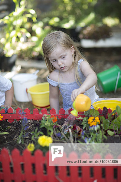 Little girl watering plants