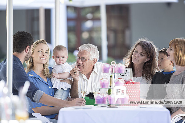 Three generations family celebrating grandfather's birthday at restaurant