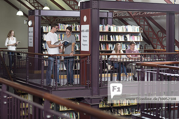 Fünf Studenten in einer Bibliothek