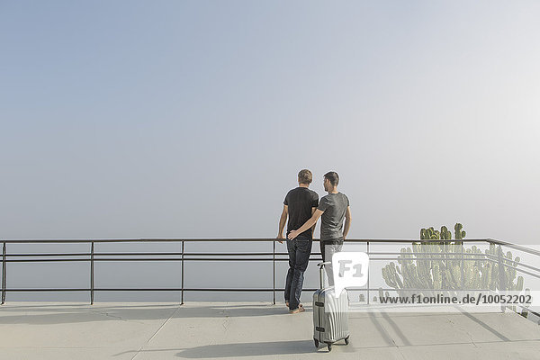Schwules Paar auf dem Balkon stehend