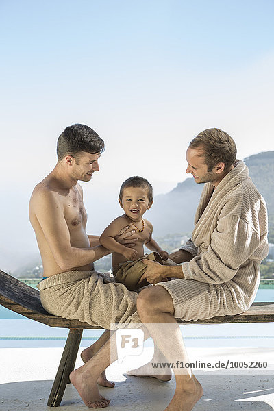 Schwules Paar mit Baby am Pool