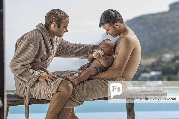 Homosexuelles Paar Flaschennahrung Baby am Pool