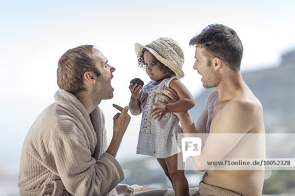 Gay couple with daughter outdoors