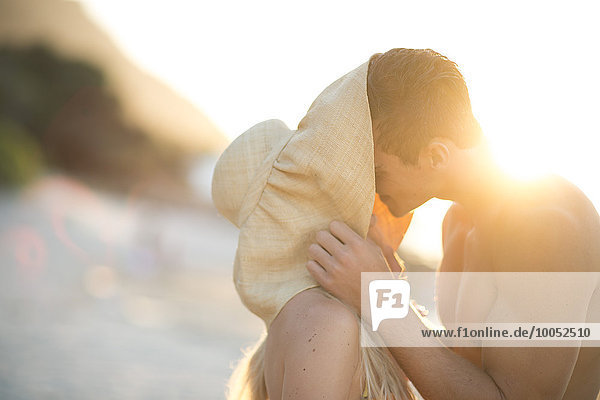 Junges Paar küsst sich am Strand