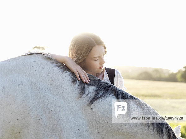 Porträt eines jungen Mädchens mit grauem Pferd