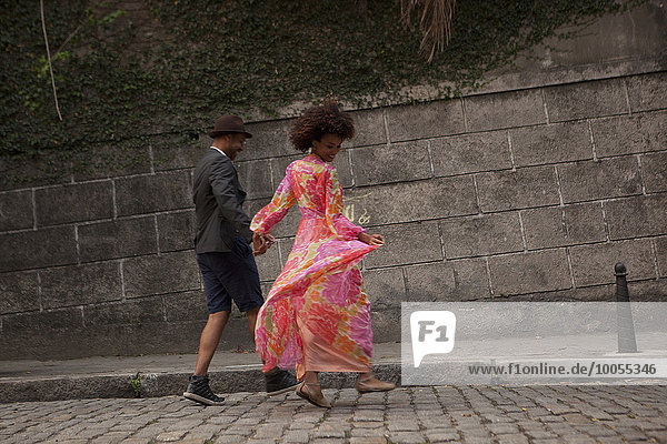 Couple walking along cobbled street  rear view