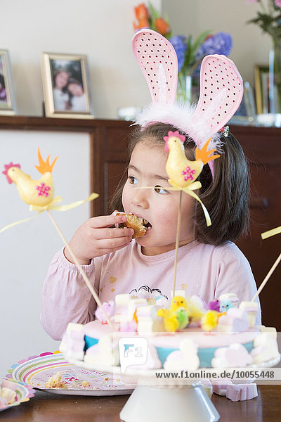 Junges Mädchen mit Hasenohren  Kuchen essen