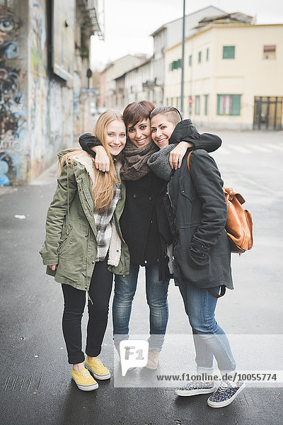 Three sisters posing on street