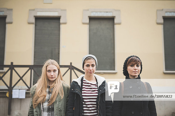 Drei Schwestern stehen vor dem Gebäude.