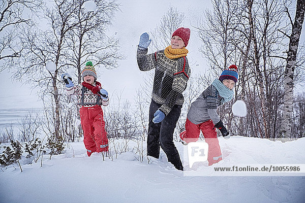 Mother and two sons throwing snowballs  Hemavan Sweden