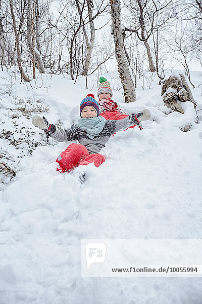 Zwei Brüder rutschen den schneebedeckten Hügel hinunter  Hemavan  Schweden