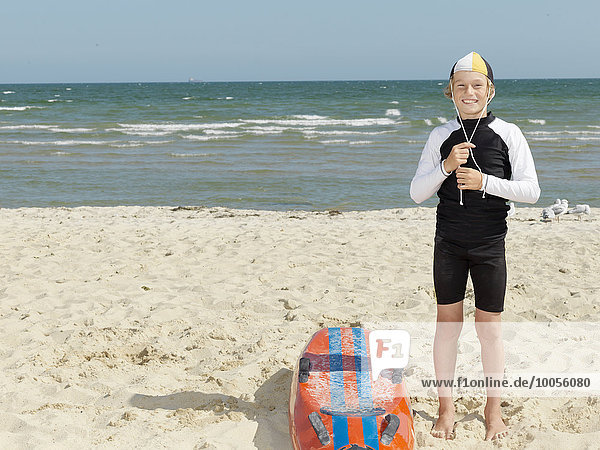 Portrait of boy nipper (child surf life savers) fastening cap at beach  Altona  Melbourne  Australia