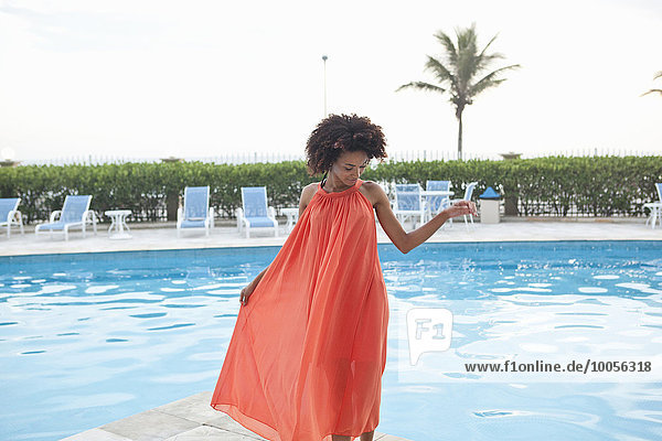 Junge Frau im orangefarbenen Kleid am Pool des Hotels  Rio De Janeiro  Brasilien