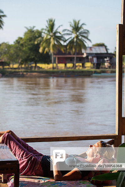 Touristinnen beim Sonnenbaden auf dem Mekong Hausboot  Don Det  Laos