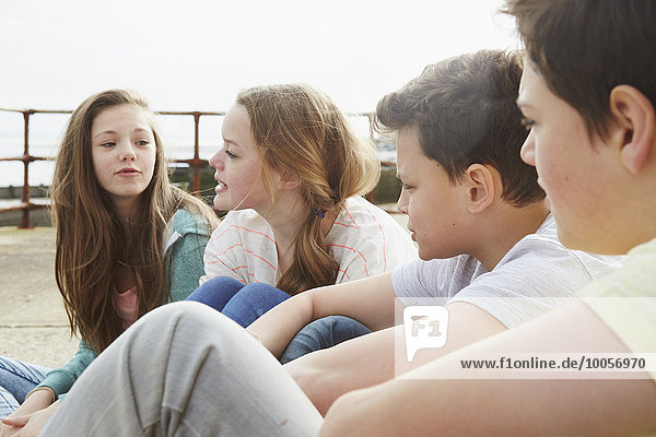 Two boys and two girls sitting outside chatting