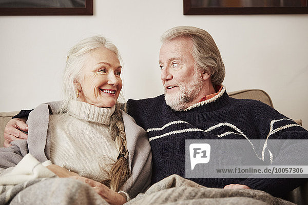 Senior couple sitting on sofa  smiling