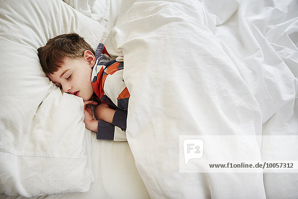 Young boy sleeping in bed