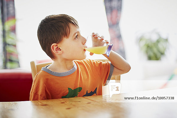 Young boy drinking glass of juice