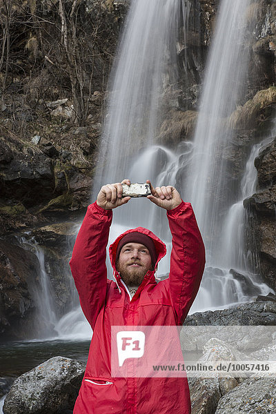 Mann fotografiert sich selbst am Wasserfall,  Fluss Toce,  Premosello,  Verbania,  Piemont,  Italien