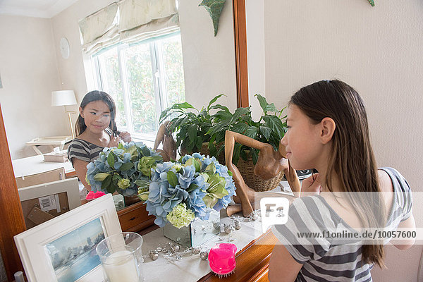 Girl looking in mirror and fiddling with her hair
