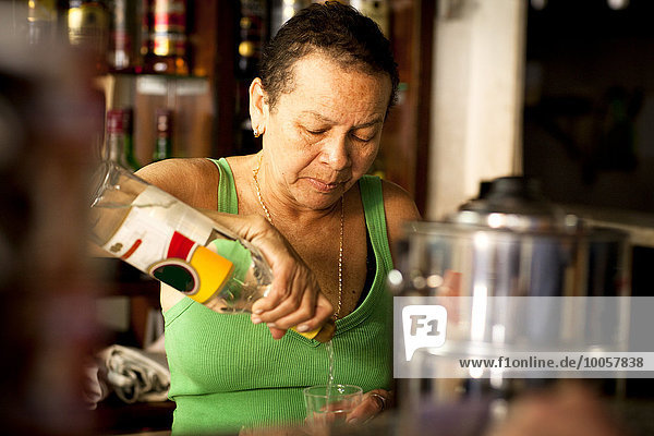 Woman serving liquor in bar