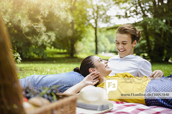 Junges Paar auf Picknickdecke liegend