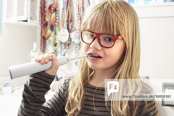 Portrait of young girl brushing teeth