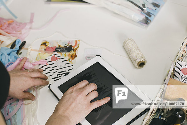Close up female designers hands using digital tablet in design studio
