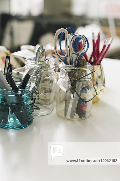 Jars of scissors  pens and pencils in design studio