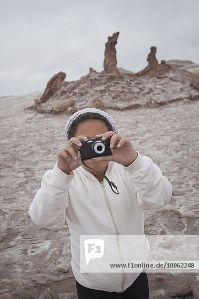 Young girl taking photograph using camera  Valley of the Moon  San Pedro  Atacama  Chile