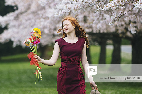 Young woman holding bunch of flowers in spring park