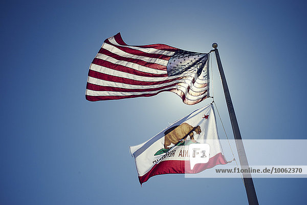 Amerikanische und kalifornische Fahnen gegen blauen Himmel  Kalifornien  USA